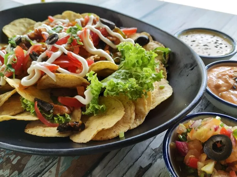 Loaded tortilla chips with guacamole, salsa and jalapeños