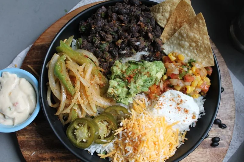 Mexican grill bowl with rice, beans, guacamole, salsa and cheese