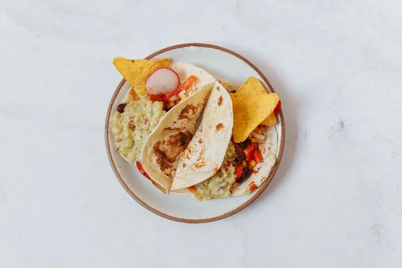 Soft tacos filled with seasoned meat, onion and cilantro